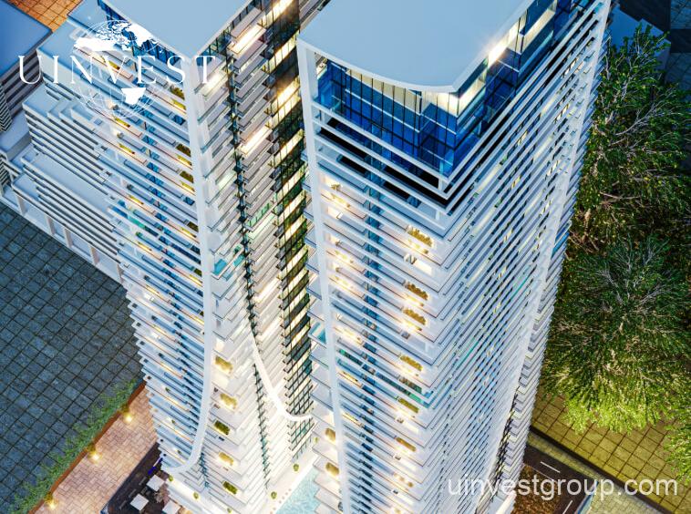 Elitz 2 twin glass towers with landscaped forecourt under a clear blue sky in Jumeirah Village Circle, Dubai.