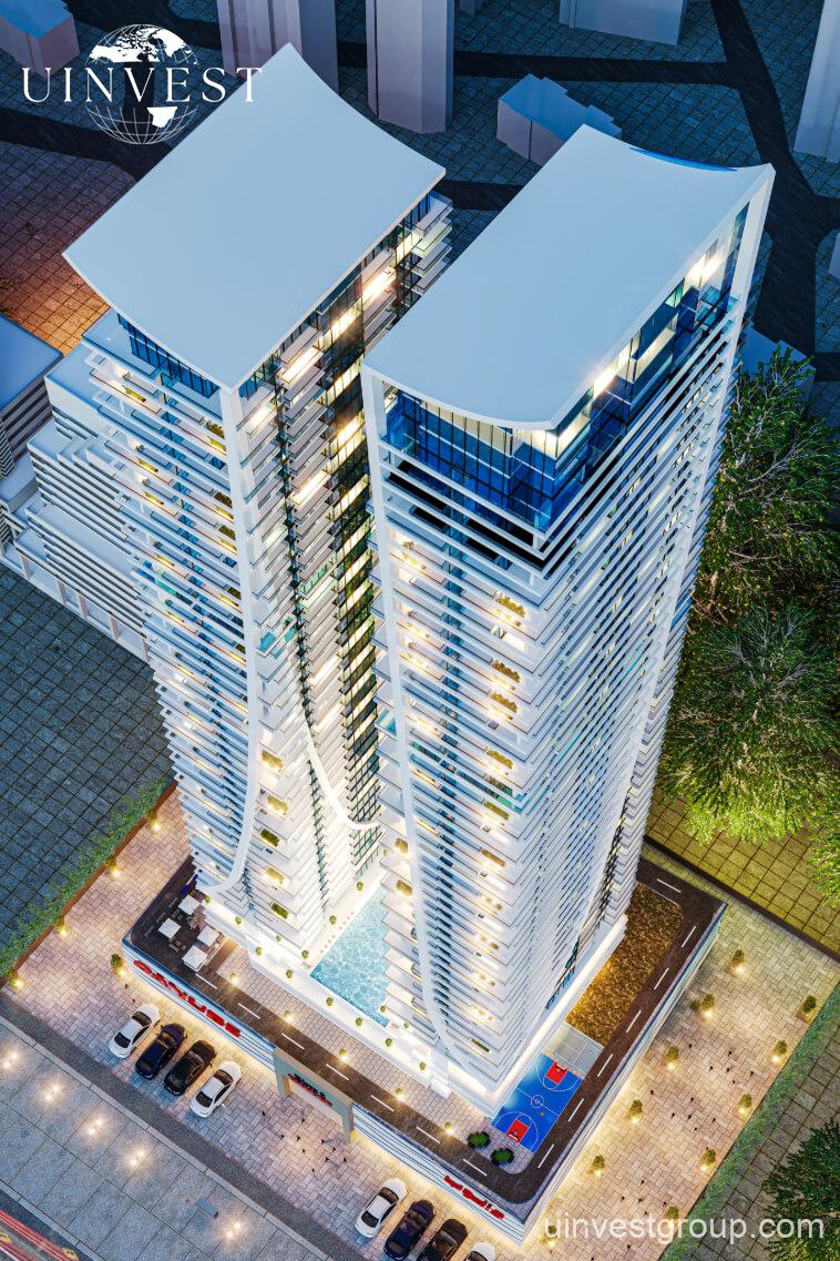 Elitz 2 twin glass towers with landscaped forecourt under a clear blue sky in Jumeirah Village Circle, Dubai.