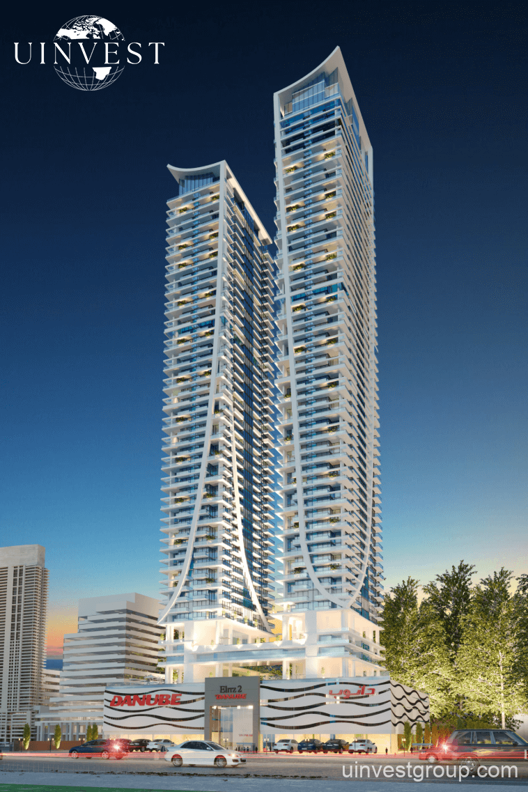 Elitz 2 twin glass towers with landscaped forecourt under a clear blue sky in Jumeirah Village Circle, Dubai.