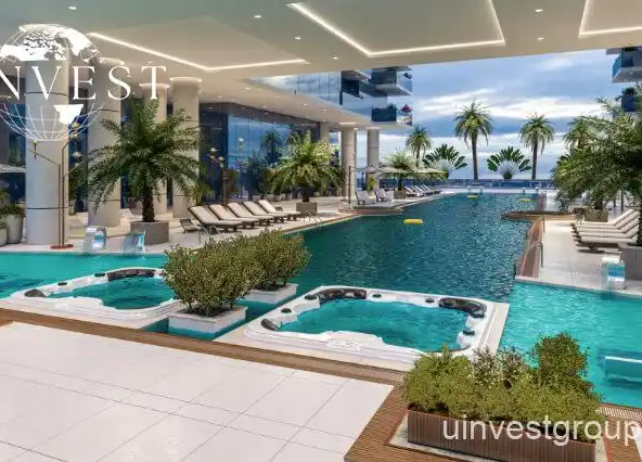 Outdoor infinity pool at Elitz 3 with glass balustrade, sun loungers, and landscaped deck.