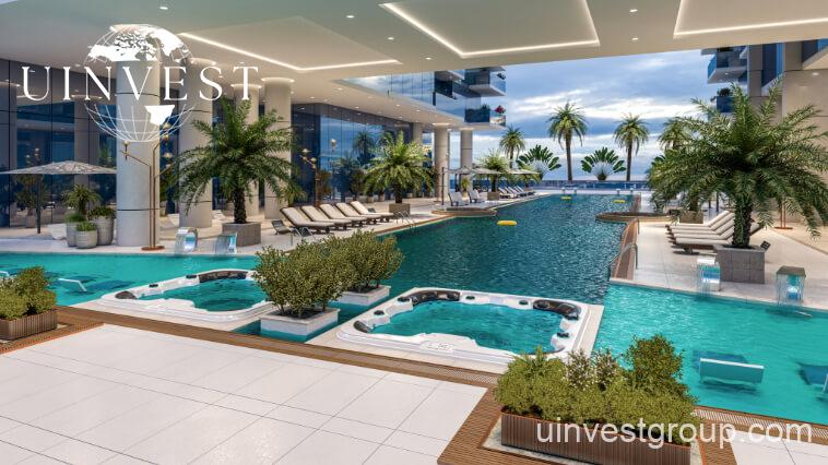 Outdoor infinity pool at Elitz 3 with glass balustrade, sun loungers, and landscaped deck.