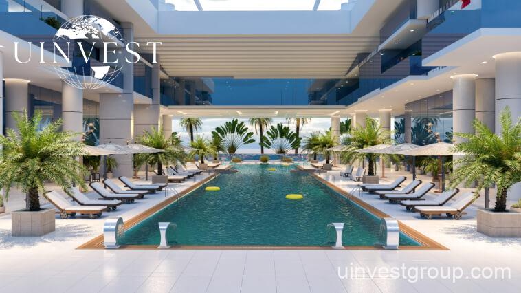 Outdoor infinity pool at Elitz 3 with glass balustrade, sun loungers, and landscaped deck.