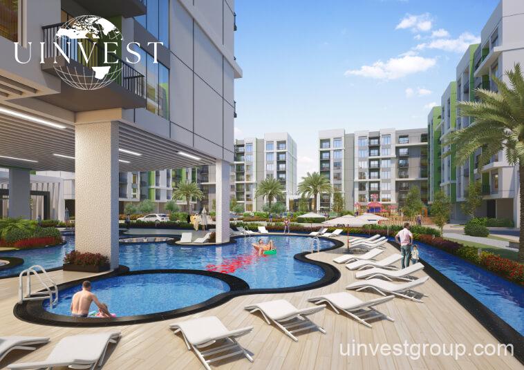 Rendering of Olivz by Danube’s modern residential towers in Al Warsan First, Dubai, featuring neutral-toned façades, landscaped gardens, water features, and swimming pools.