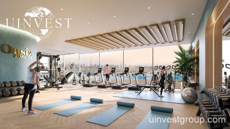 Exterior view of Oasiz by Danube in Dubai Silicon Oasis, a 38-storey glass-clad tower with landscaped podium and central pool.