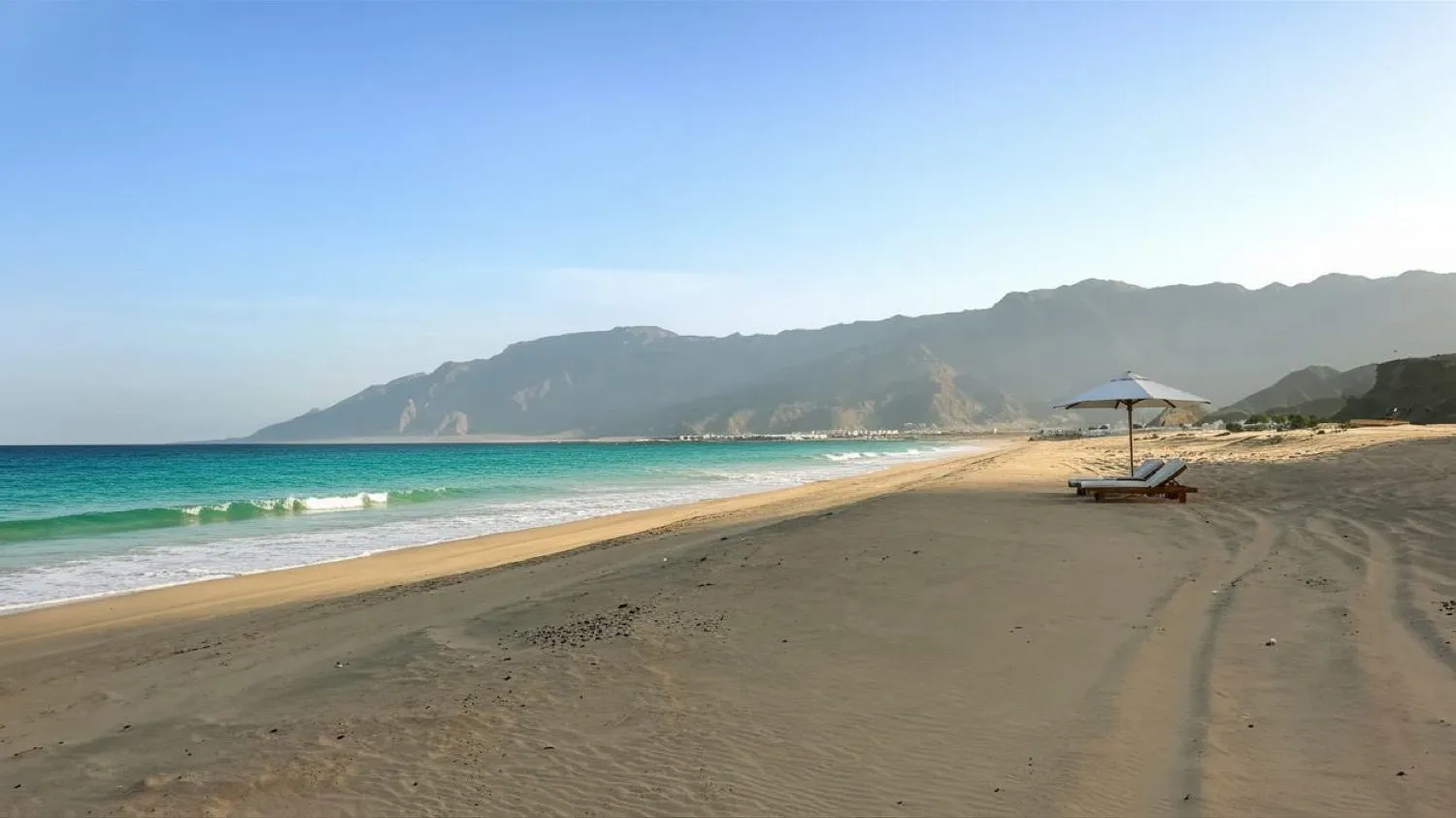 Beach houses for sale in Oman — white sand beach at As Sifah below the Al Hajar mountains