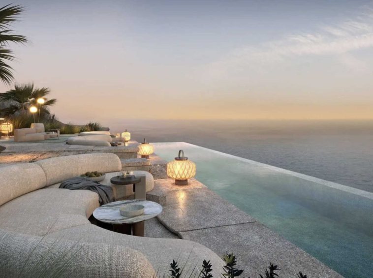 Clifftop infinity pool and lounge terrace at AIDA at sunset over the Gulf of Oman.