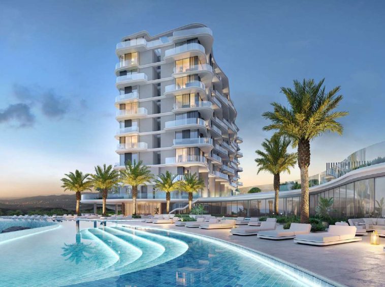 The Great Escape building at dusk with its wave-form terraces above the infinity pool deck in AIDA, Muscat.