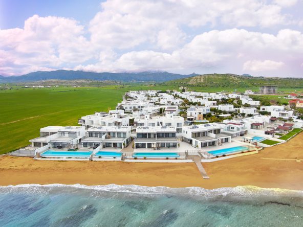 Aerial view of Caesar Beach villas with pools on the shore