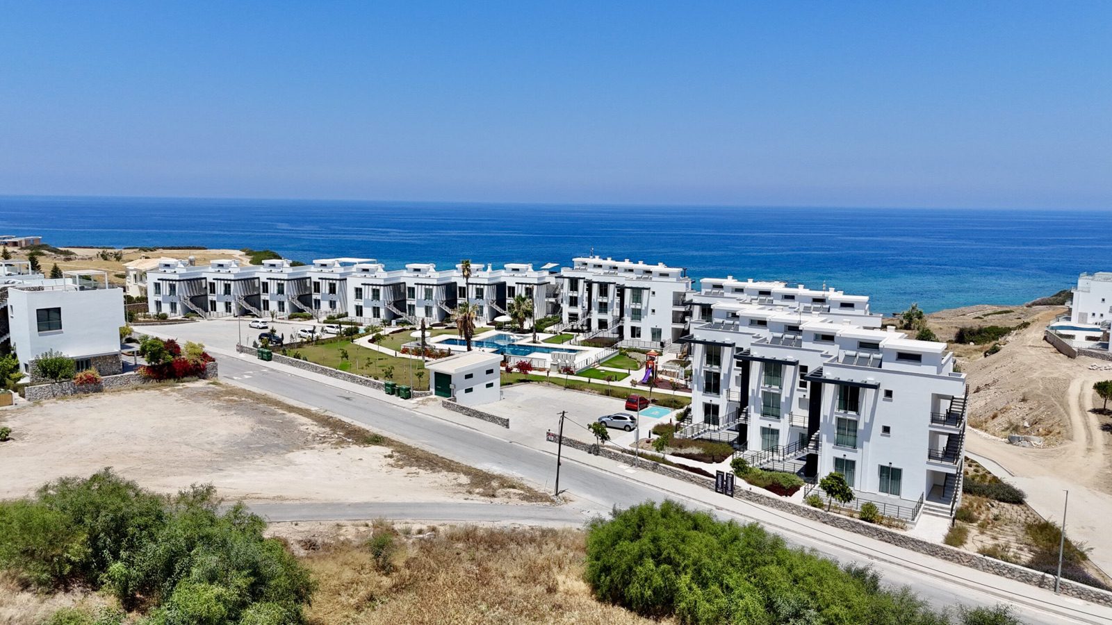 Aerial photo: the apartment blocks beside the road with the sea beyond