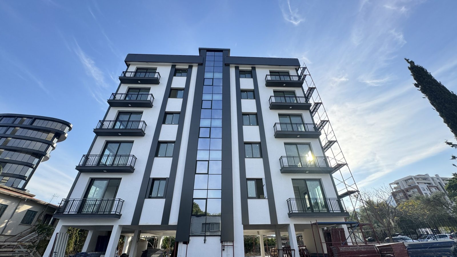 Photo of the front facade with a central glazed stair column and balconies