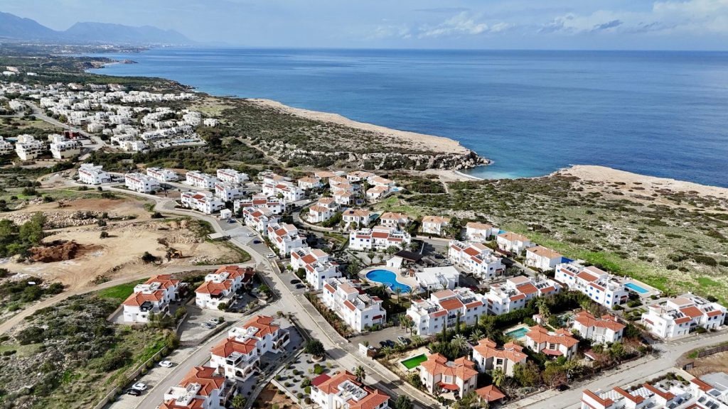 Sea Magic Park Esentepe: free-form pool, white apartment buildings and mountains behind