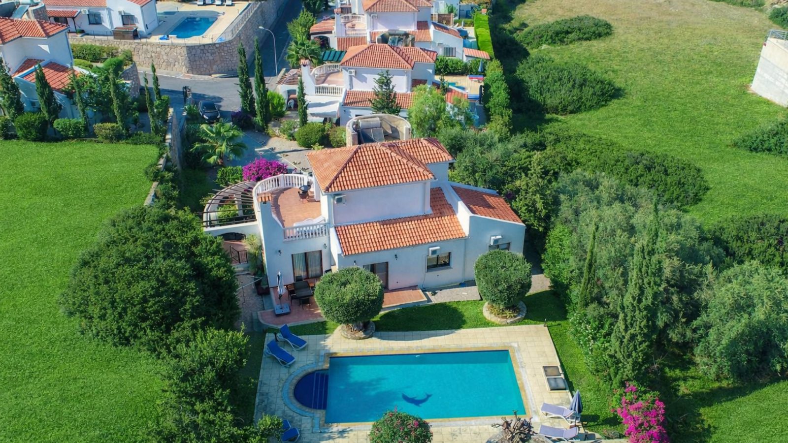 Aerial view of a villa with terracotta roof, garden and private swimming pool