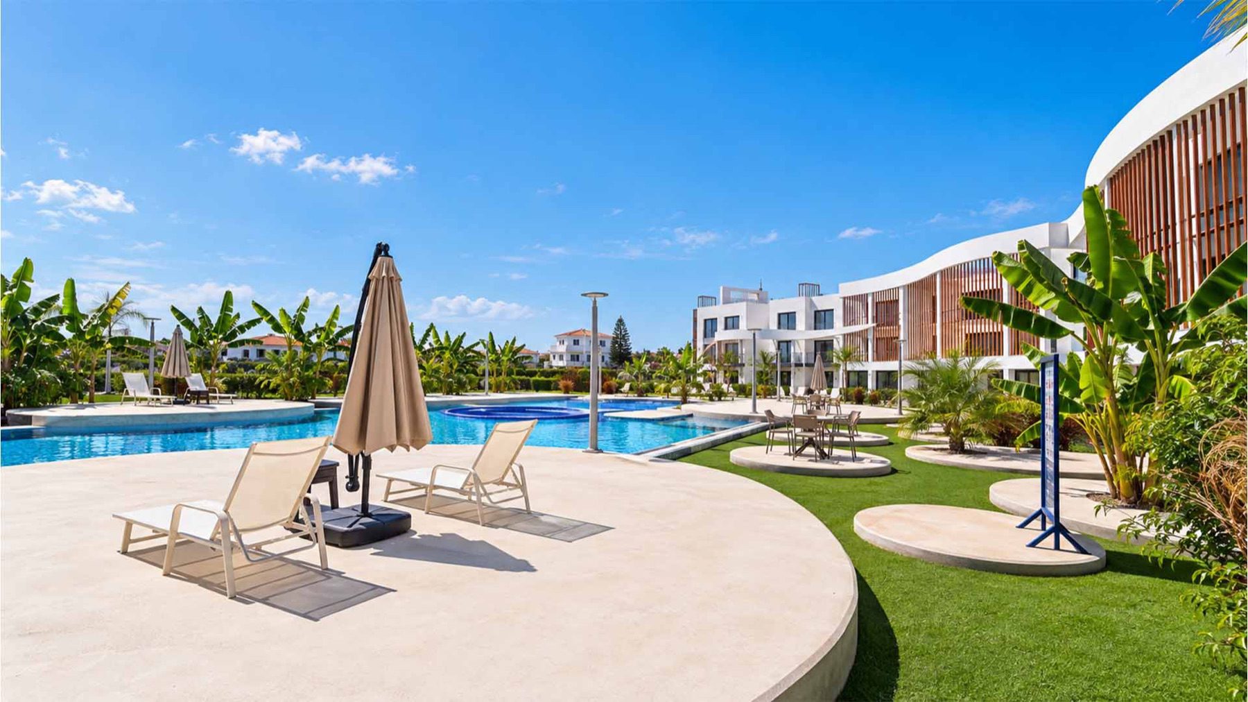 Neo Residence swimming pool with sun loungers and terraced apartment blocks