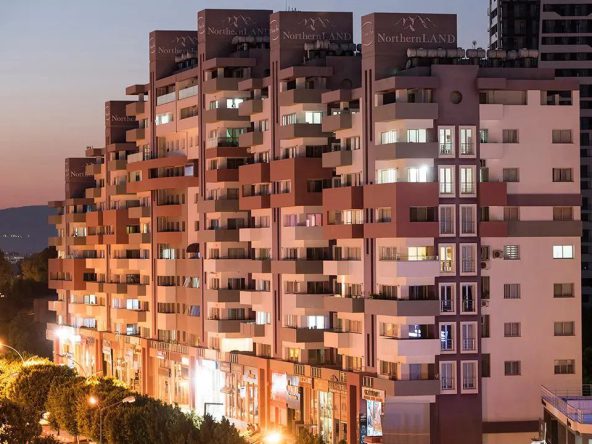 Terraced apartment block at dusk with lit windows