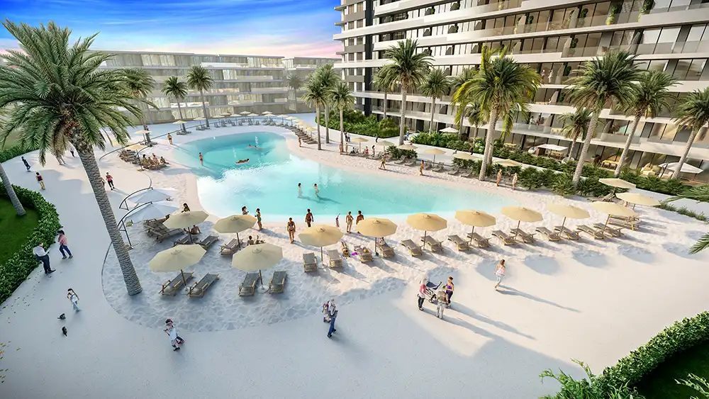 Render of the sand-edged lagoon pool with sun loungers between apartment blocks