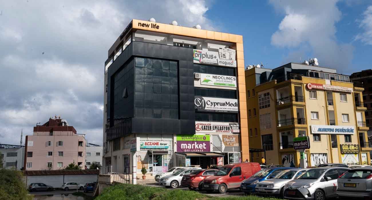 New Life building facade with dark glazing and copper-coloured top frame, street view