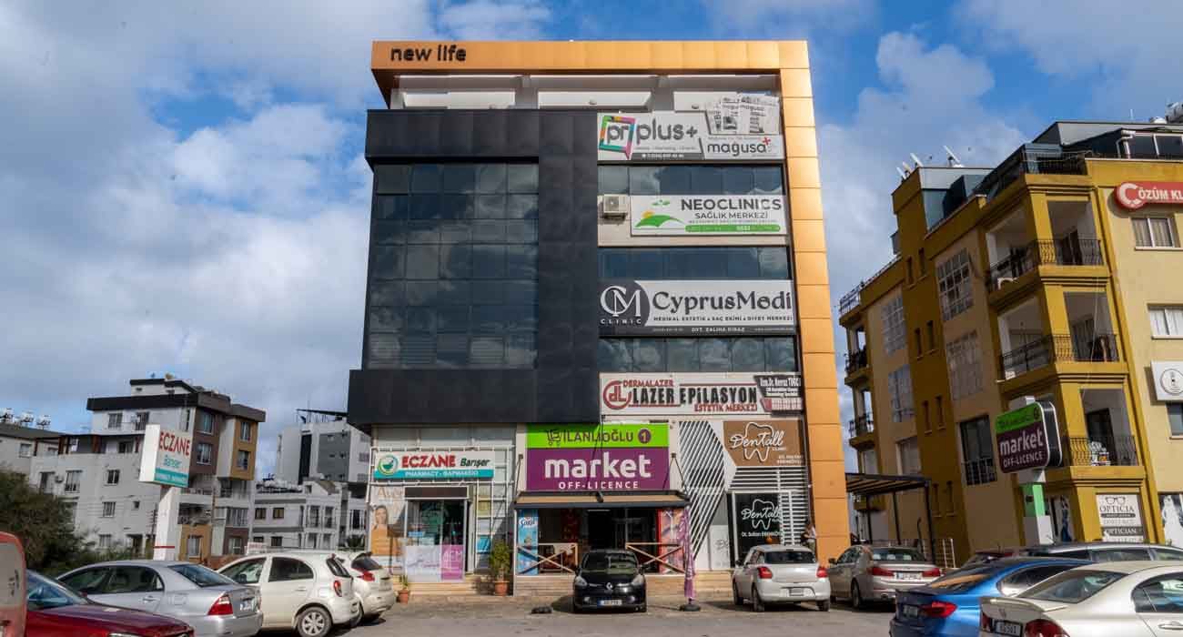Front of the New Life building with ground-floor shops and neighbouring apartment block