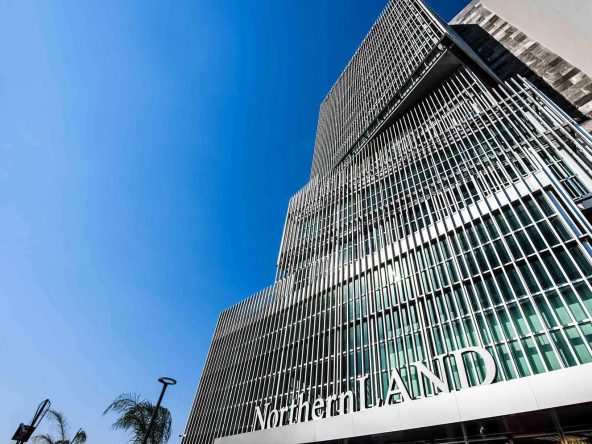 Glass-fronted office and residential tower with company name on the facade