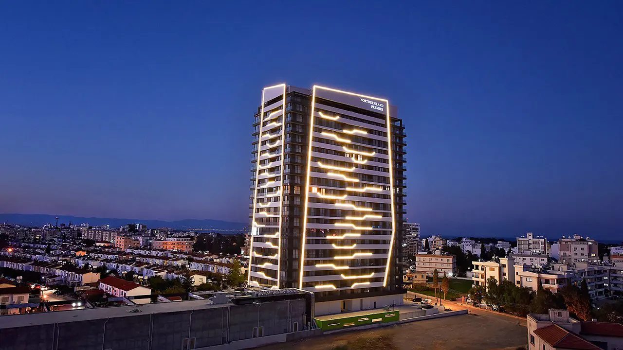 Northernland Premier tower lit at dusk above surrounding residential areas