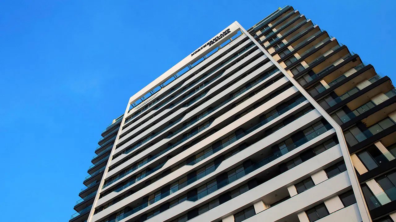 Upward view of the Premier tower facade with balconies and the sky