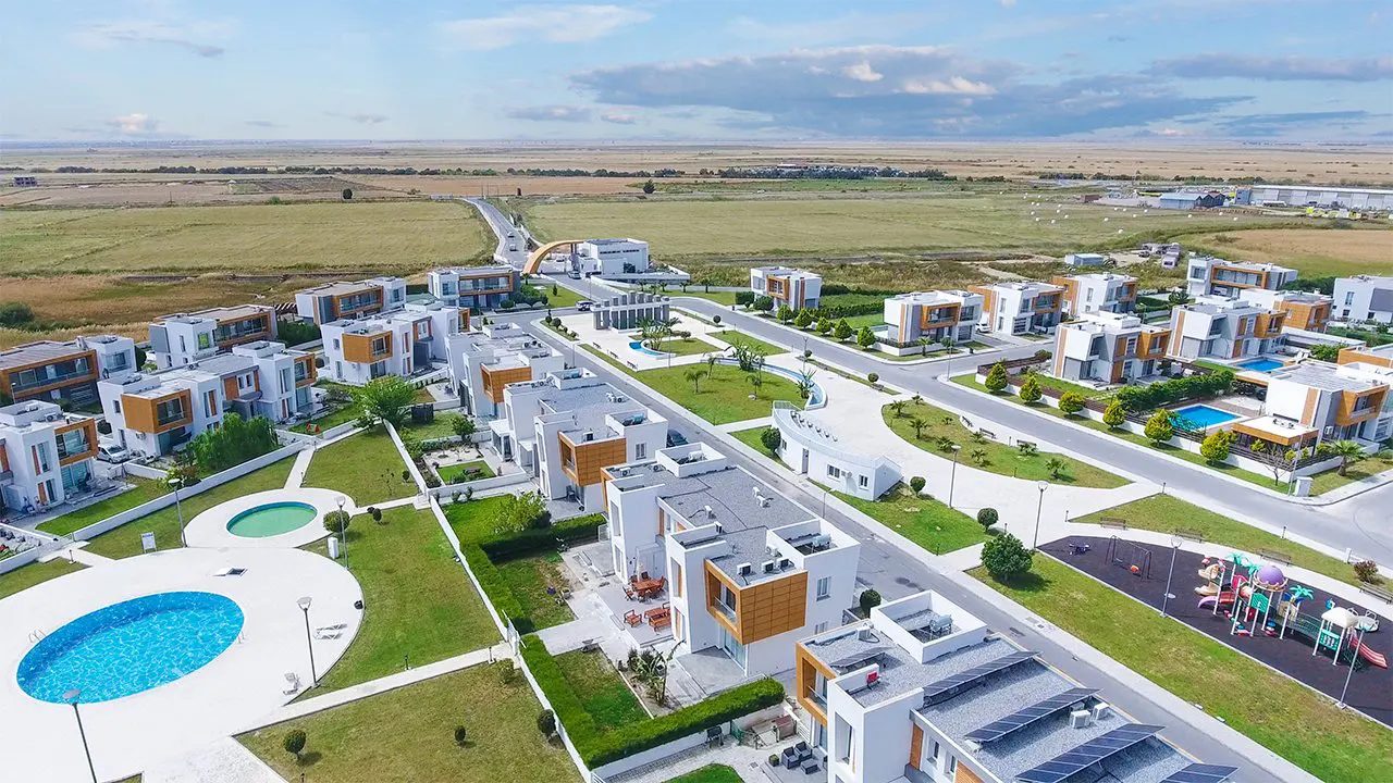 Aerial view of Sakli Kent villas, communal pools and playground in open farmland