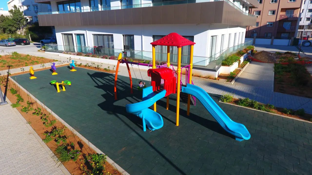 Children playground with slide in the Viapark grounds, residential building behind